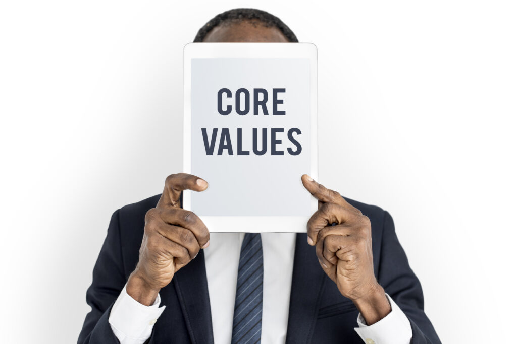 a man holding a paper written on it core values