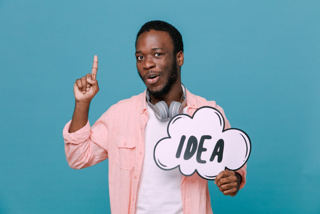 a young man holding his one single finger  up and holding an idea card