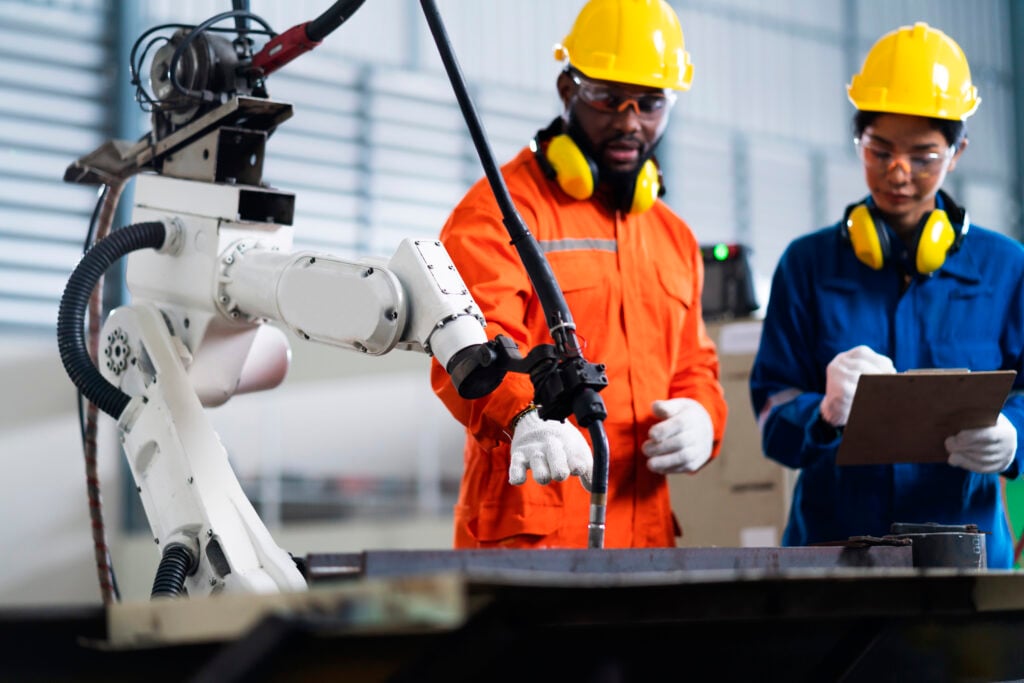 A black man and woman using a robot